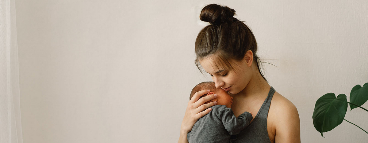 Junge Frau hält Baby in ihrem Arm