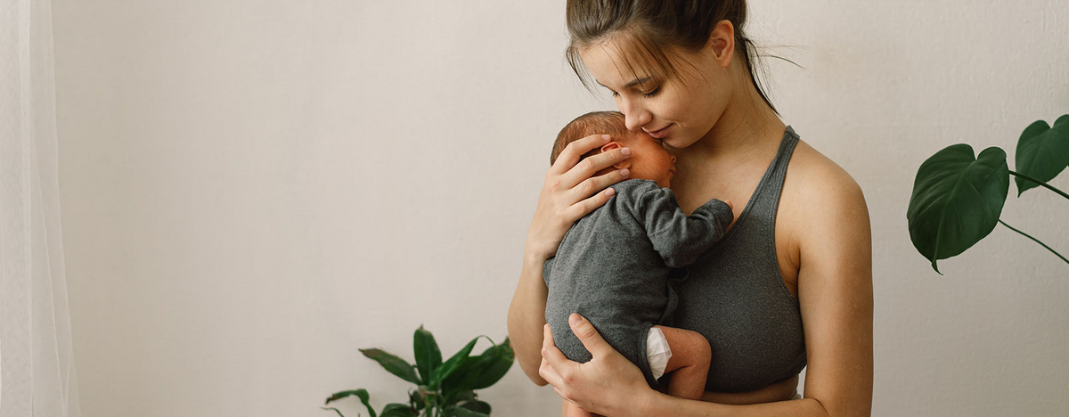 Junge Frau hält Baby in ihrem Arm