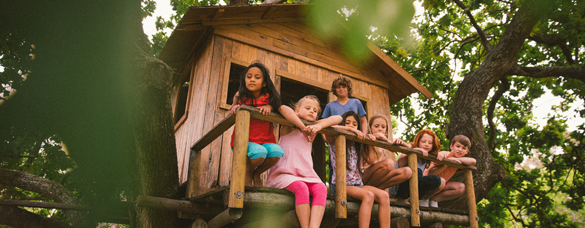 Eine Gruppe kleiner Kinder sitzt in einem Baumhaus