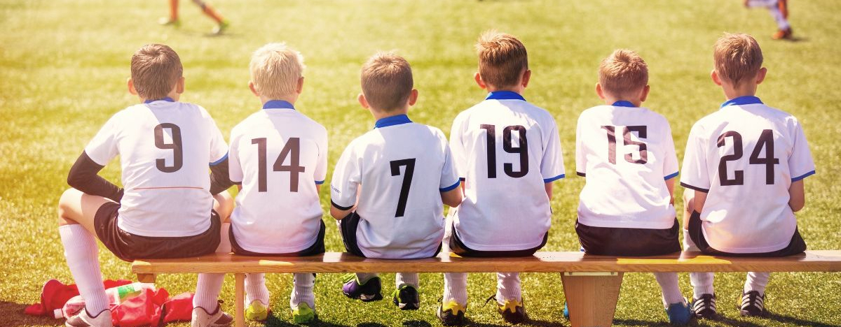 Jungs auf einer Auswechselbank beim Fußball