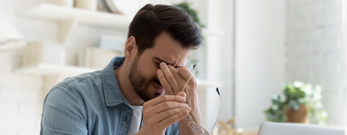 Mann vor dem PC reibt sich die Augen