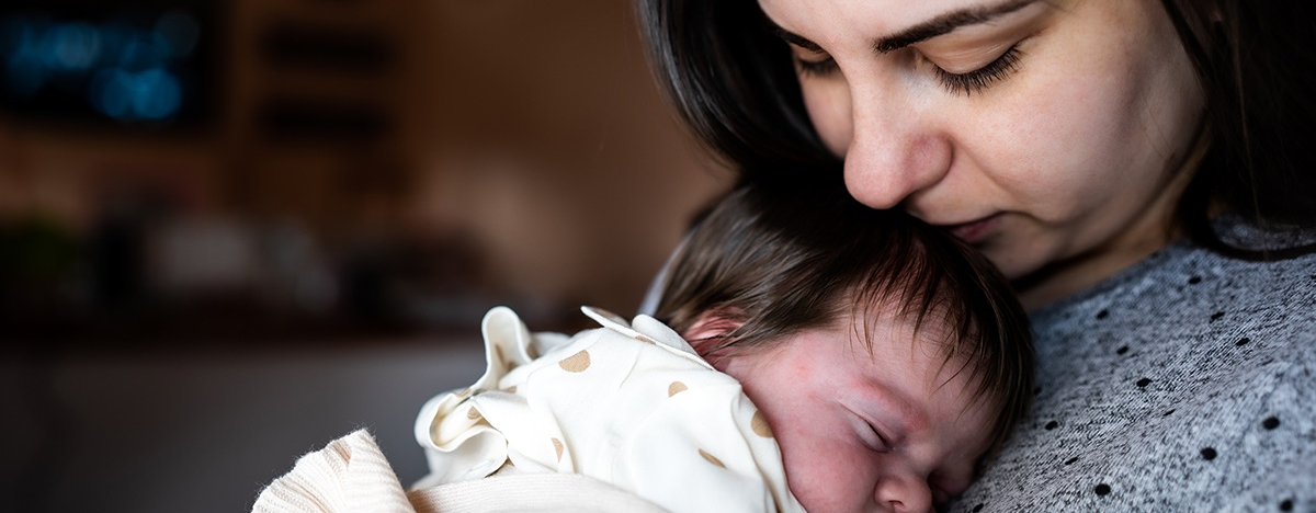 Mutter hält neugeborenes Baby auf dem Arm