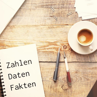 Das Bild zeigt ein Tisch auf dem ein Notebook, ein Block und eine Kaffeetasse stehen.