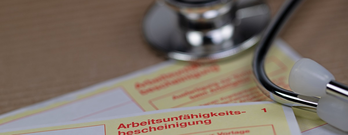 Bild zeigt Arbeitsunfähigkeitsbescheinigung und Stethoskop