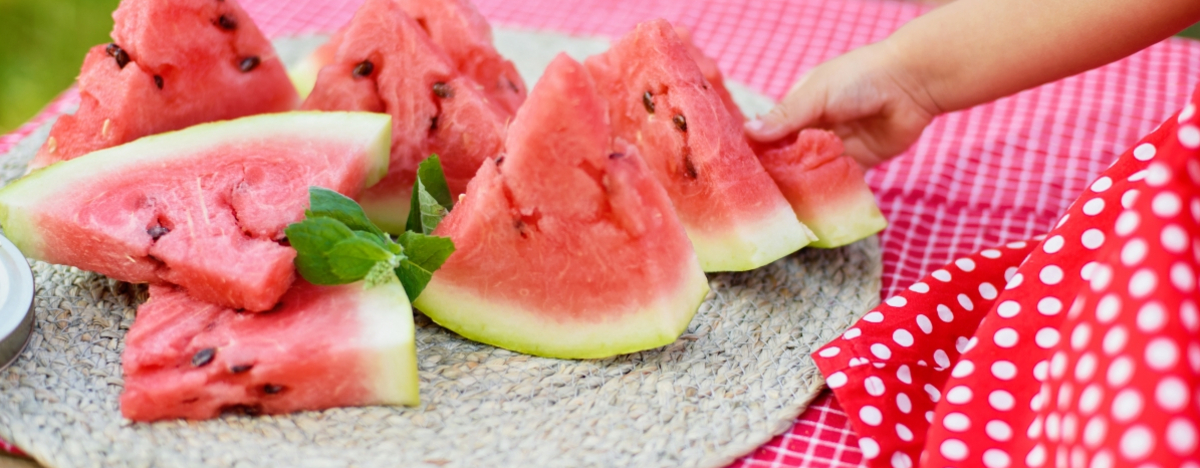 Mädchen greift nach Wassermelone