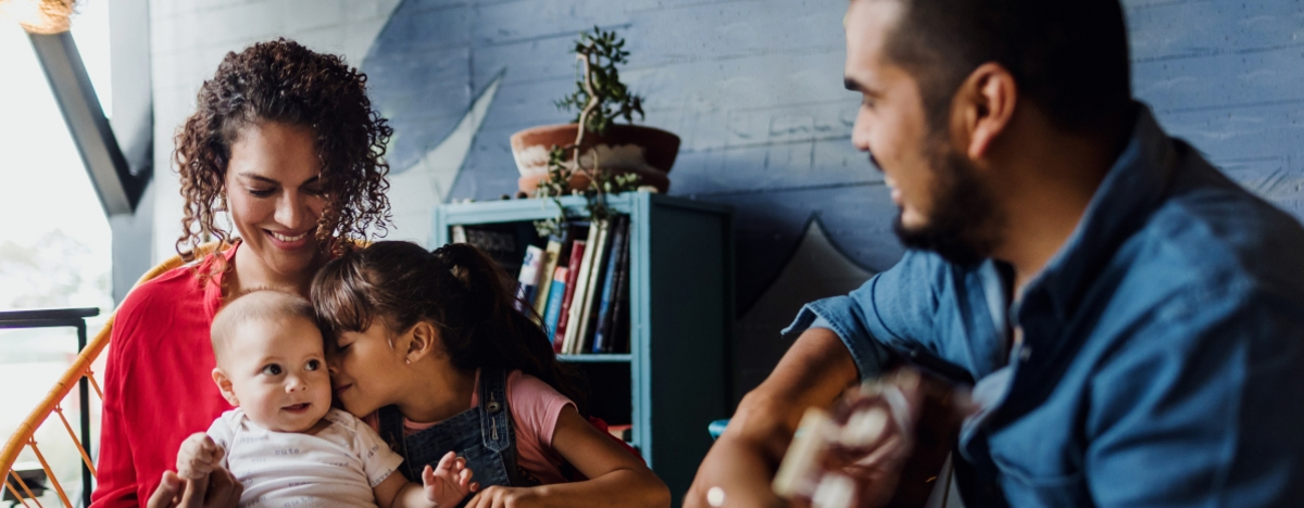 Vater spielt Gitarre, singt und hat Spaß mit seiner Familie