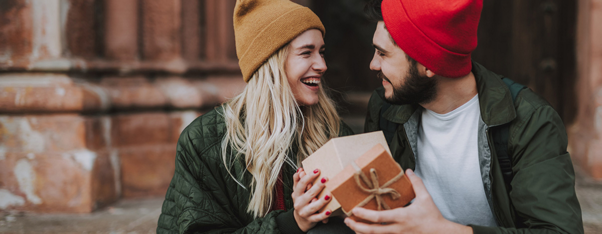 Junges Paar hält geöffnete Geschenkbox