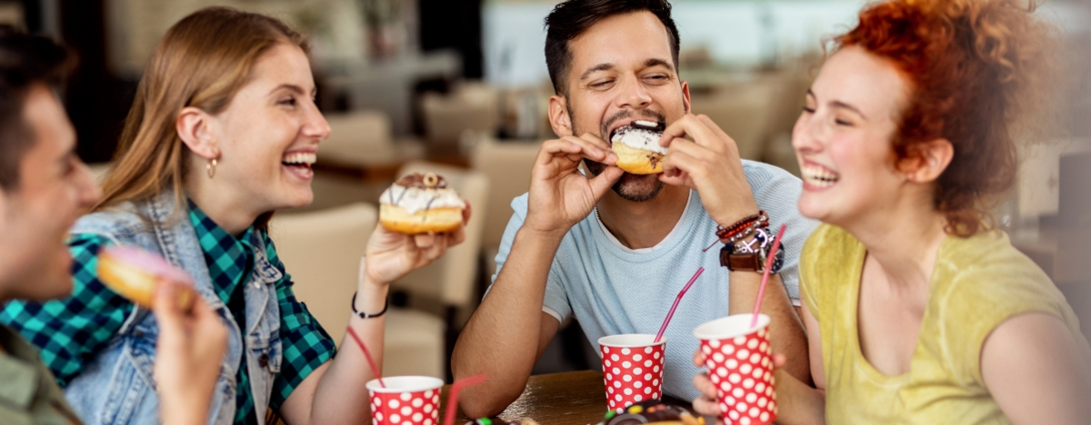 Freunde essen Donuts und lachen dabei