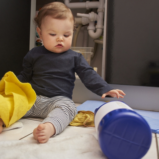 Baby spielt mit Reinigungsmitteln