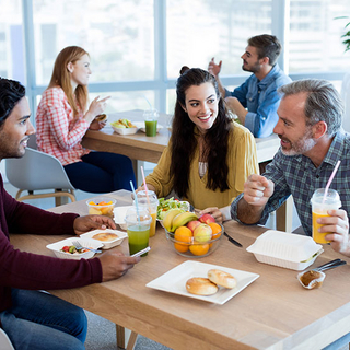 Kollegen beim Mittagessen mit gesundem Essen in der Kantine