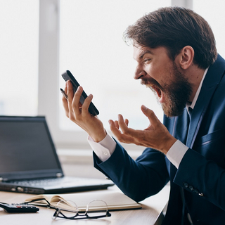 Mann schreit ins Telefon