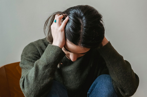 Frau wühlt sich in den Haaren vor Angst