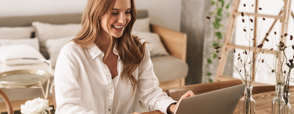 Frau sitzt zu Hause an ihrem Laptop