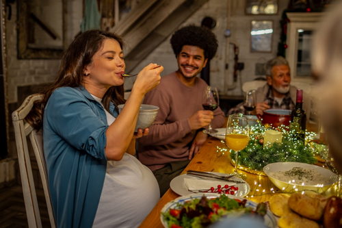 schwangere Frau ist auf einer Feier einen Salat