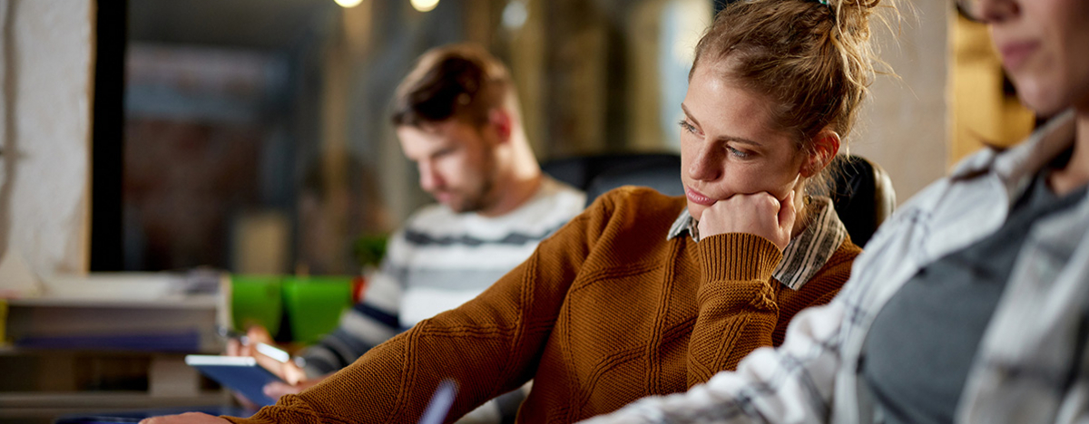 Gelangweilte Frau, die im Büro am Laptop arbeitet.