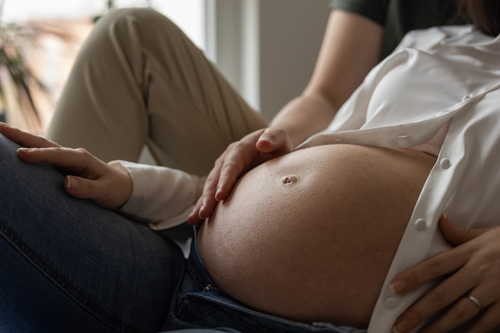 Mann reibt den Bauch seiner schwangeren Frau