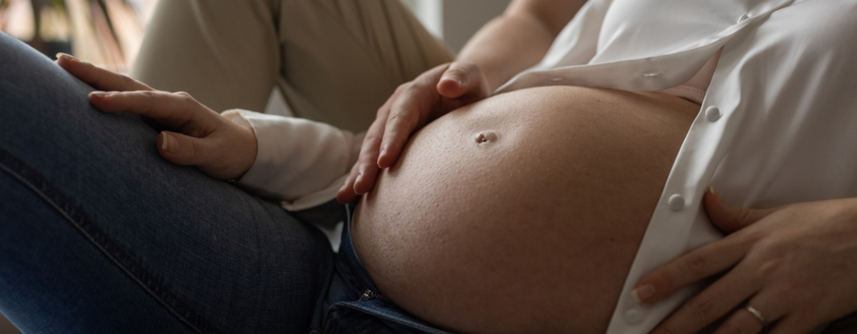 Mann reibt den Bauch seiner schwangeren Frau