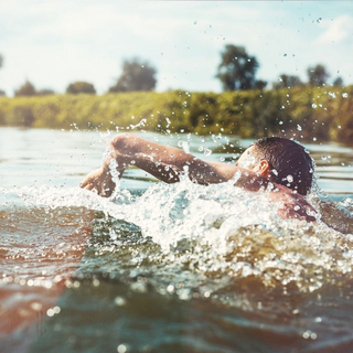 Mann schwimmt in einem See