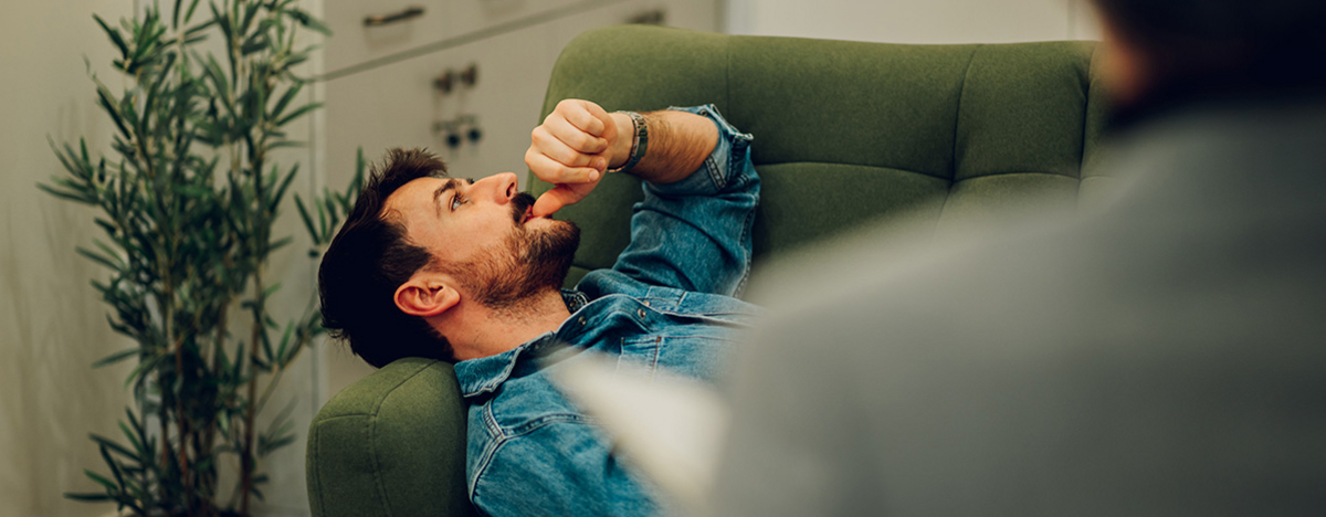 Ein depressiver Mann liegt auf einem Sofa in der Praxis eines Psychotherapeuten.