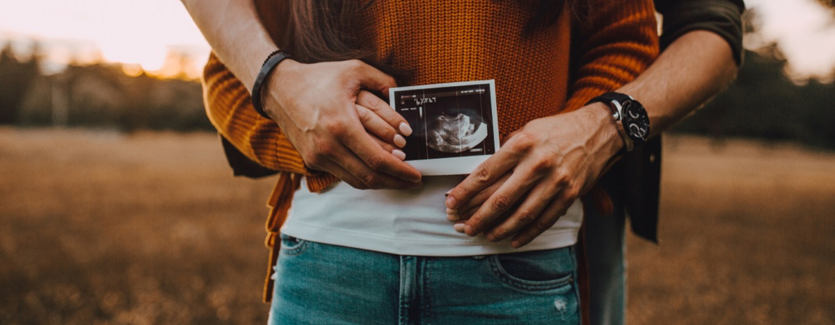 Babybauch einer Frau mit Ultraschallbild