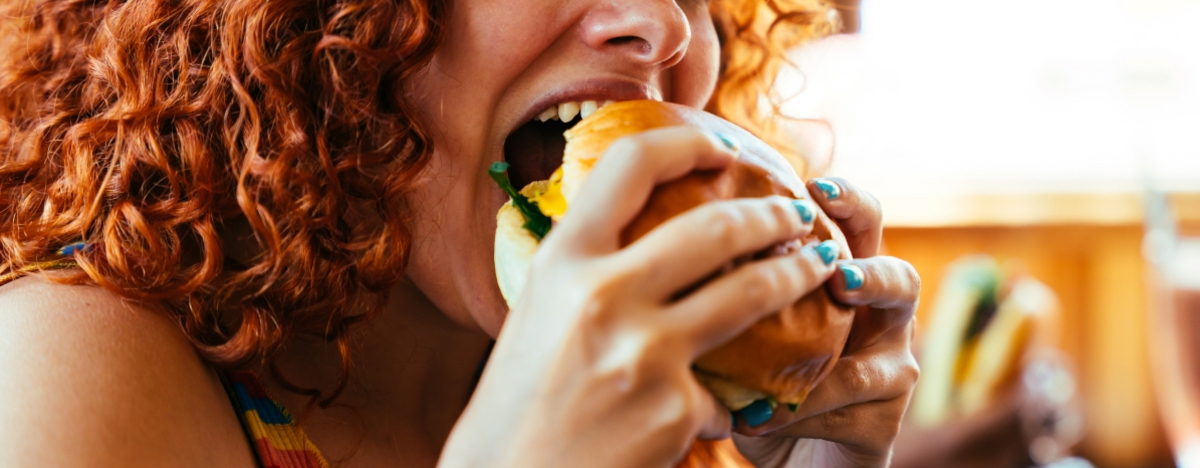 Frau beißt in einen Burger