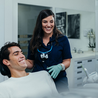 Foto einer Zahnärztin mit ihrem Patient in der Zahnarztpraxis.